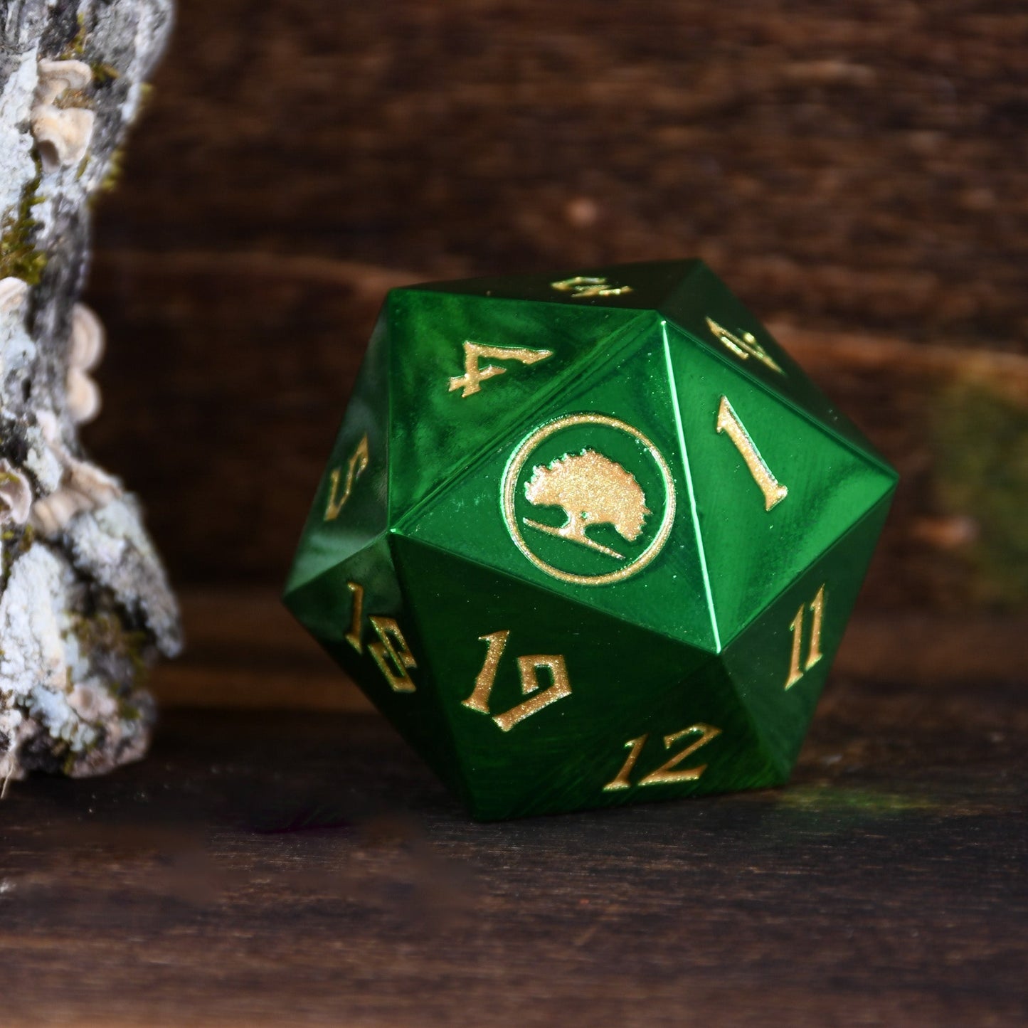 Green polyhedral dice with gold numbers and a logo on a dark background