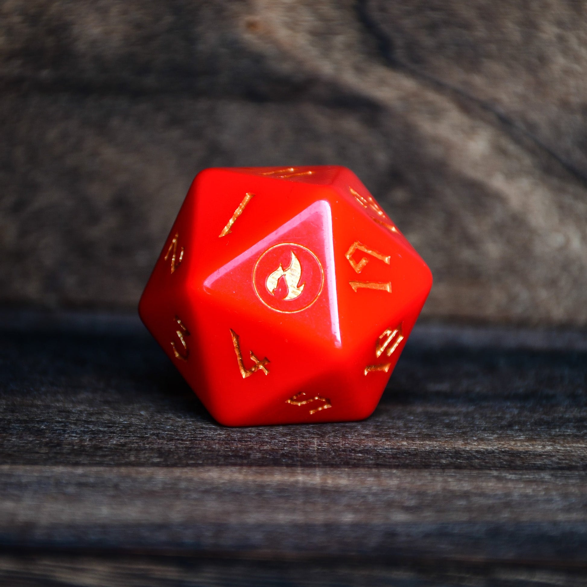 Red polyhedral dice with numbers on a wooden surface