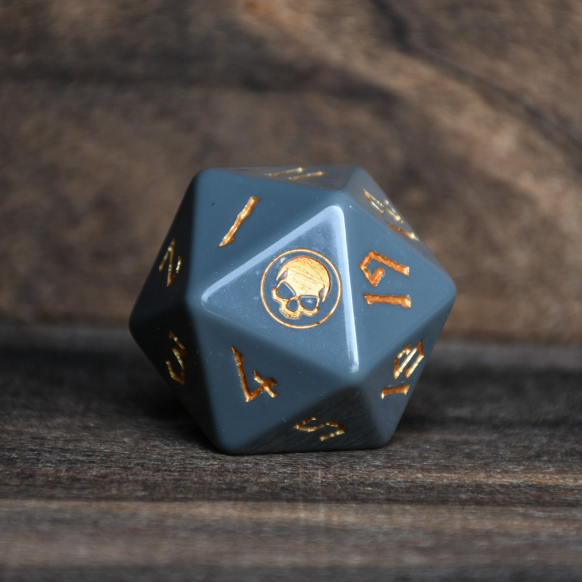 Blue polyhedral dice with gold numbers on a wooden surface