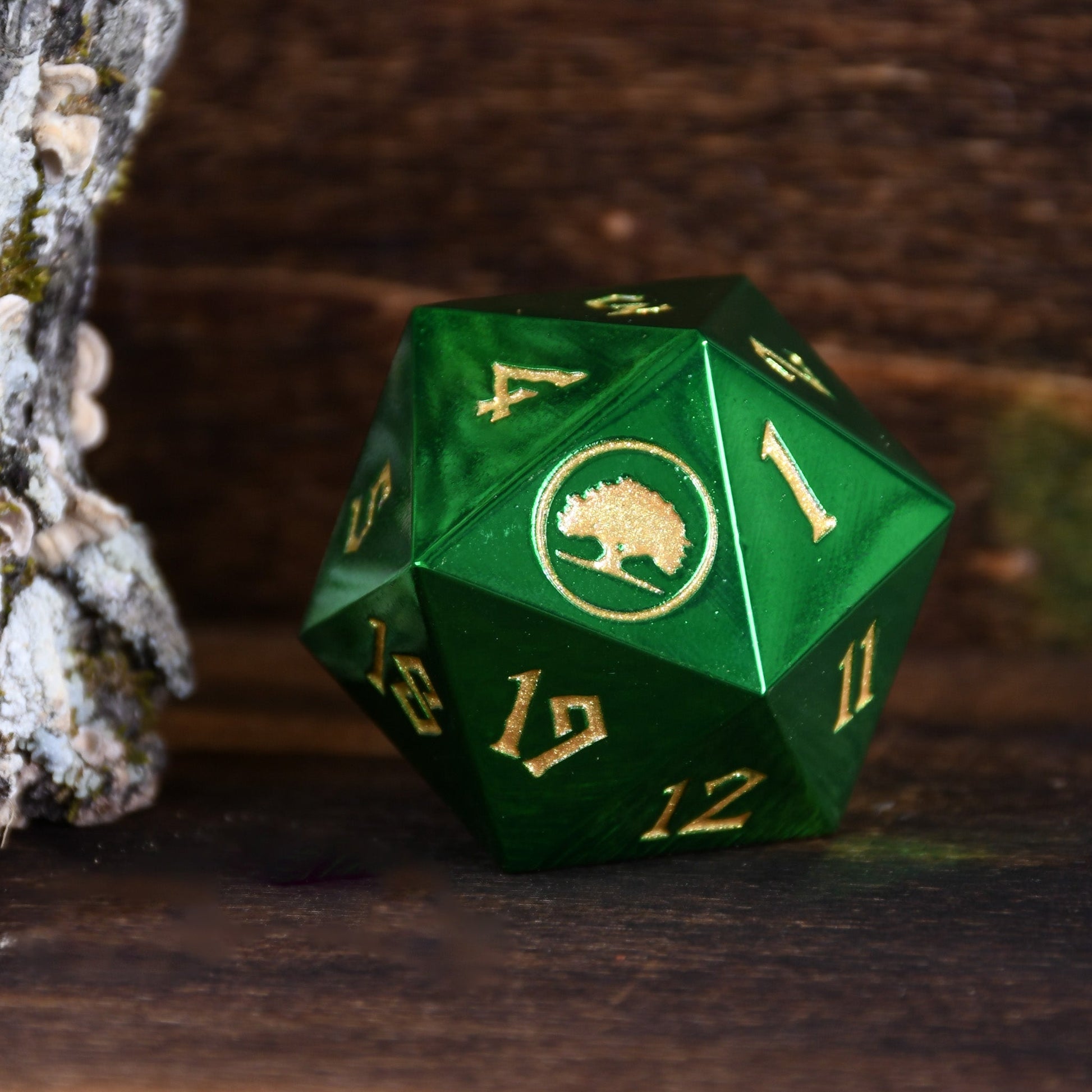 Green polyhedral dice with gold numbers and a logo on a dark background