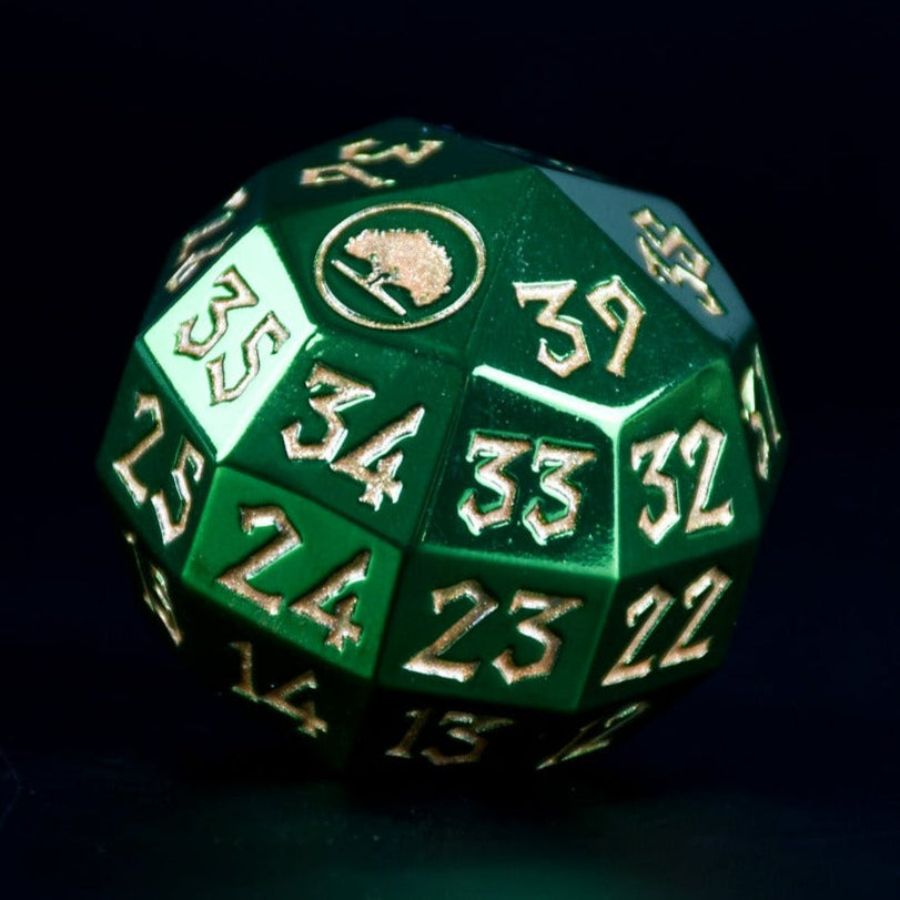 A solid-metal spindown life counter d40 die, in green with gold numbers, displayed on a wooden surface for magic the gathering and trading card games