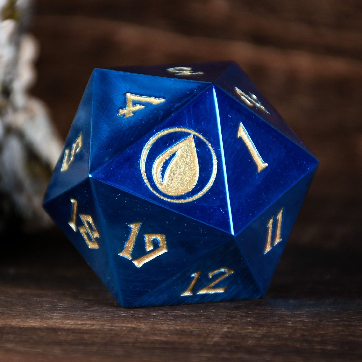 Blue polyhedral dice with gold numbers on a wooden surface