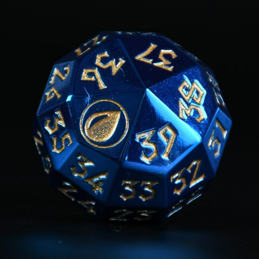 A solid-metal spindown life counter dice, with blue coloring and gold numbers, displayed on a wooden surface for magic the gathering