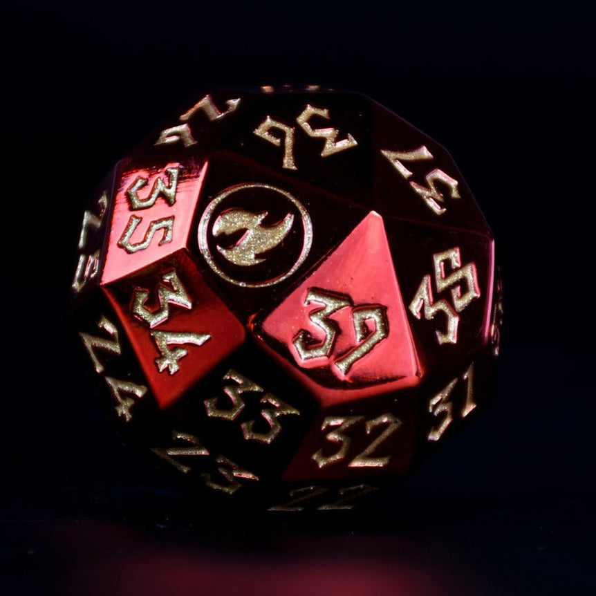 A solid-metal spindown d40 life counter dice with red and gold colors, placed on a wooden surface for magic the gathering and trading card games