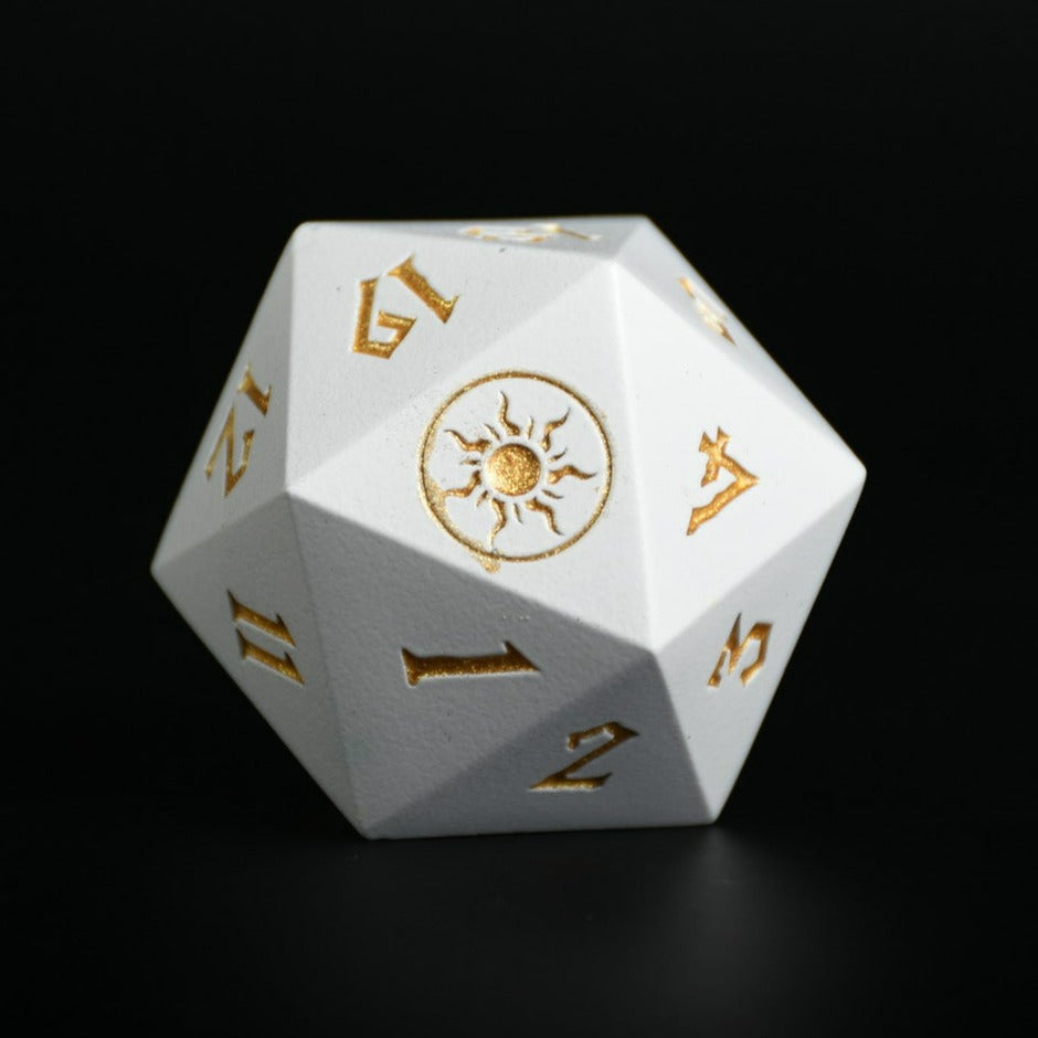 A white-colored metal D20 dice with gold numbers and symbols, used as a spindown life counter for trading card games, displayed on a wooden surface.